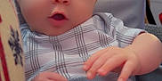 Symphanie is registered to the contest to win money with this photo: baby, infant, child, car_seat, seatbelt, plaid_clothing, indoor, window_blinds, red_hat, hand, face, blue_eyes, curious_expression, soft_light, furniture, person, portrait, sitting, closeup, baby_clothes