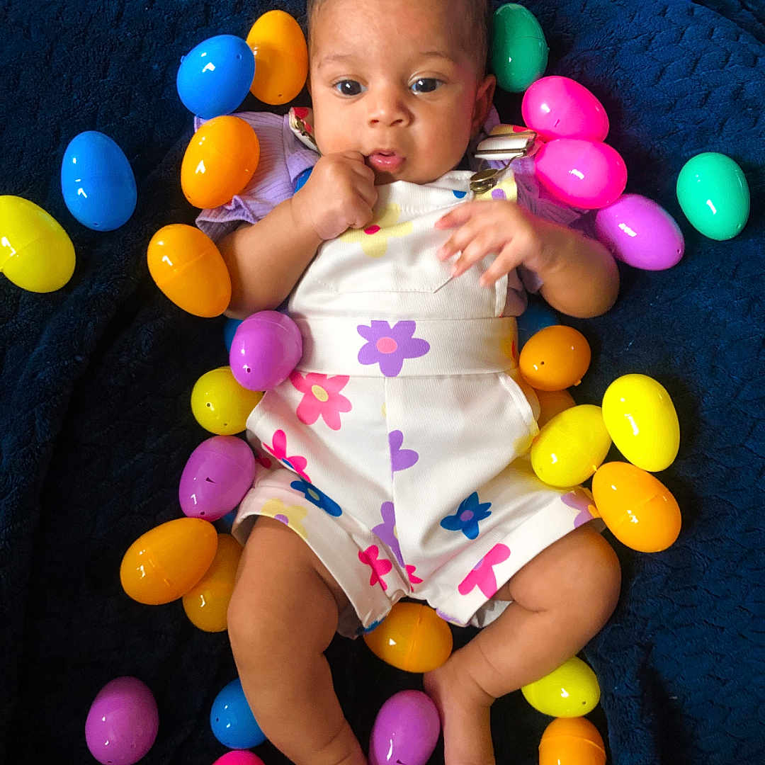 Halo is registered to the contest to win money with this photo: accessories, baby, balloon, bodypart, candy, egg, face, finger, food, hand, head, newborn, people, person, photography, portrait, purple, sitting, sphere, sweets