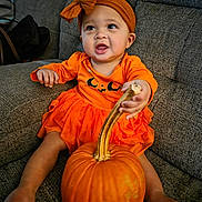 Leia is registered to the contest to win money with this photo: autumn, baby, celebration, child, couch, cozy, cute, fall, festive, happy, headband, holiday, indoor, orange_clothing, person, pumpkin, seasonal, sitting, smiling, toddler