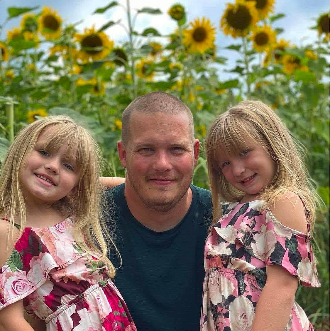 Paisley is registered to the contest to win money with this photo: botany, child, event, facial_expression, flower, fun, grass, happy, joy, leaf, leisure, people, people_in_nature, person, pink, plant, sky, smile, summer, t_shirt