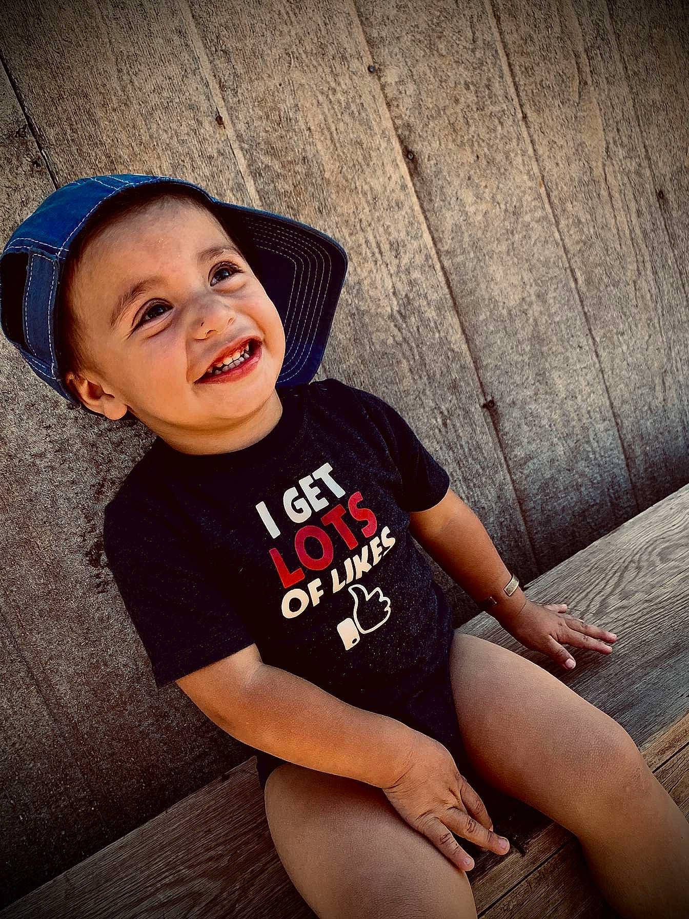 Colt is registered to the contest to win money with this photo: child, cool, elbow, flash_photography, flooring, happy, human_leg, knee, leisure, person, shorts, shoulder, sitting, skin, sleeve, smile, sportswear, t_shirt, thigh, toddler