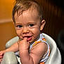baby, child, infant, smiling, finger_in_mouth, high_chair, sleeveless_outfit, cute, portrait, indoors, seat, skin, face, happy, young, person, expression, hair, looking_at_camera, candid