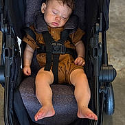 Easton joined the competition — help win amazing prizes! baby, sleeping, stroller, infant, child, brown_outfit, footwearless, seatbelt, relaxed, indoor, cute, peaceful, toddler, headrest, soft_lighting, black_stroller, small_child, hands, legs, nap