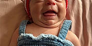 Ailani is registered to the contest to win money with this photo: baby, smiling, hat, red, white, blue, denim, clothing, star_patch, quilted_blanket, lying_down, happy, cute, child, infant, portrait, face, skin, headwear, fabric