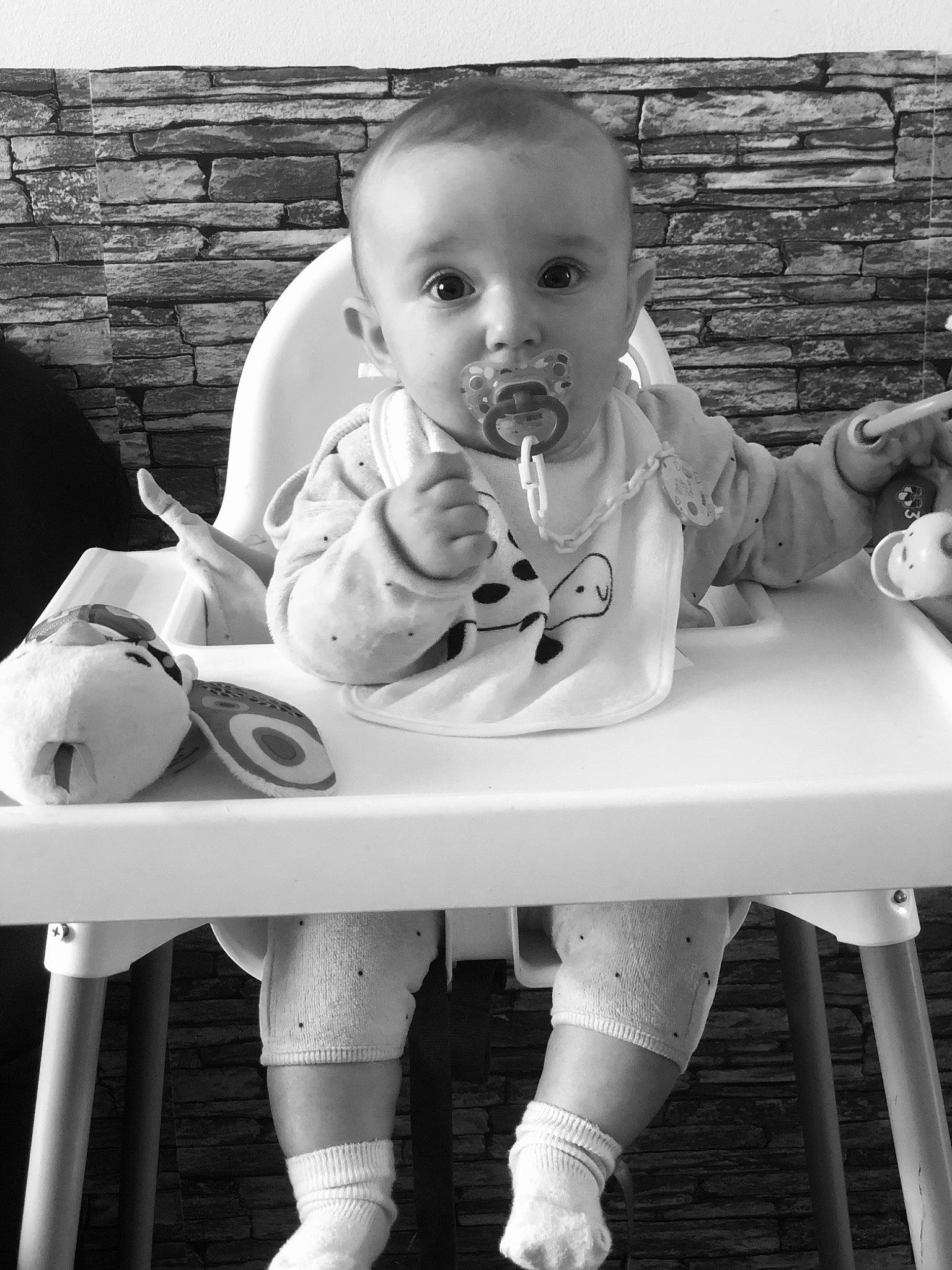 Milla participe au concours pour gagner de l'argent avec cette photo : arm, baby, black, black_and_white, chair, child, furniture, hairstyle, hand, human_body, leg, organ, person, photograph, product, shorts, standing, style, table, toddler