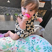 Mylie is registered to the contest to win money with this photo: baby, blue_eyes, chewing, child, clothing, curious, cushion, cute, face, floral, hair, infant, outdoor, pattern, pink, playpen, sitting, skin, toddler, toy