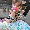 baby, blue_eyes, chewing, child, clothing, curious, cushion, cute, face, floral, hair, infant, outdoor, pattern, pink, playpen, sitting, skin, toddler, toy