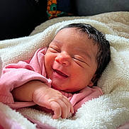 Laïka a rejoint le concours — aidez-le/la à gagner de superbes lots ! baby, newborn, smiling, sleeping, blanket, pink_clothing, infant, cute, peaceful, soft_texture, face, hand, wrapped, cozy, indoors, portrait, happy, child, human, young
