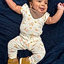 baby, infant, smiling, face, arms, floral_outfit, sneakers, brown_shoes, blanket, textured_blanket, lying_down, happy, cute, child, person, indoors, apparel, footwear, skin, head