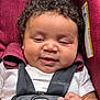 baby, car_seat, cheeks, child, closeup, curly_hair, cute, hand, happy, indoor, infant, portrait, red_fabric, safety, seatbelt, skin, smile, straps, white_shirt, young