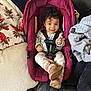 baby, blanket, boots, car_seat, child, clothing, comfort, couch, cozy, curly_hair, fabric, happy, home, indoor, infant, person, pillow, portrait, seatbelt, smiling