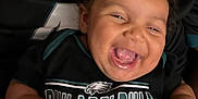 Aurora is registered to the contest to win money with this photo: adult, baby, black_clothing, celebration, child, closeup, curly_hair, eagles_logo, face, hands, happiness, indoor, joy, laughing, person, philadelphia_eagles, portrait, smiling, sportswear, team_spirit