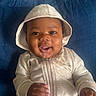 baby, hoodie, smile, drool, infant, child, cute, portrait, happy, clothing, sitting, indoor, person, cushion, blue, zipper, hand, face, headwear, closeup