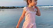 Luna joined the competition — help win amazing prizes! child, girl, beach, ocean, water, sand, waves, rocks, sky, sunlight, swimsuit, pink, standing, young, portrait, outdoor, nature, vacation, summer, reflection