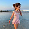 child, girl, beach, ocean, water, sand, waves, rocks, sky, sunlight, swimsuit, pink, standing, young, portrait, outdoor, nature, vacation, summer, reflection