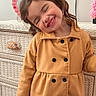 Luna is registered to the contest to win money with this photo: buttoned_coat, child, closed_eyes, coat, cute, decor, dresser, furniture, girl, happy, indoor, mustard_yellow, person, pigtails, pink_flowers, portrait, smiling, standing, wicker, wood_floor