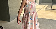Luna joined the competition — help win amazing prizes! casual, child, door, dress, face, floor, footwear, girl, hair, light, outdoor, patio, pattern, person, sandals, shadow, smile, standing, summer, wall