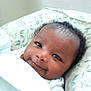Kadeem joined the competition — help win amazing prizes! baby, smile, face, infant, blanket, pillow, curly_hair, resting, cute, indoors, portrait, child, happy, young, closeup, skin, head, cozy, comfort, peaceful