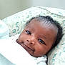 Kadeem is registered to the contest to win money with this photo: baby, infant, smiling, face, blanket, curly_hair, cute, closeup, child, portrait, lying_down, indoors, soft_texture, comfort, peaceful, young_child, skin, head, expression, happy