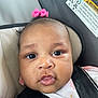Aaliyah is registered to the contest to win money with this photo: baby, child, pink_bow, car_seat, seat_belt, close_up, face, infant, cute, straps, warning_label, indoor, portrait, young_child, curious, clothing, headwear, person, skin, eyes