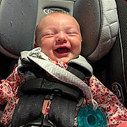 Lilie joined the competition — help win amazing prizes! baby, child, infant, smiling, laughing, car_seat, harness, pacifier, floral_clothing, pink, portrait, face, indoor, seated, baby_carrier, safety_buckle, happy, close_up, photography, adorable