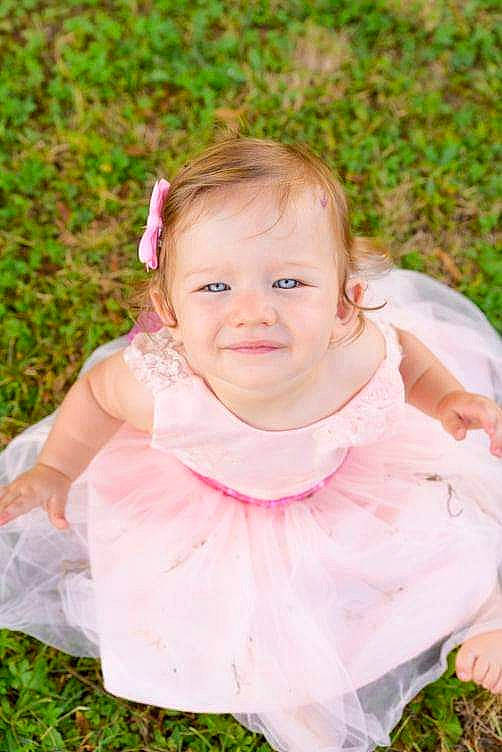 Lianna a rejoint le concours — aidez-le/la à gagner de superbes lots ! baby, baby_toddler_clothing, blond, child, dress, eye, face, flash_photography, grass, hand, happy, iris, joy, leisure, lip, people_in_nature, person, pink, plant, skin