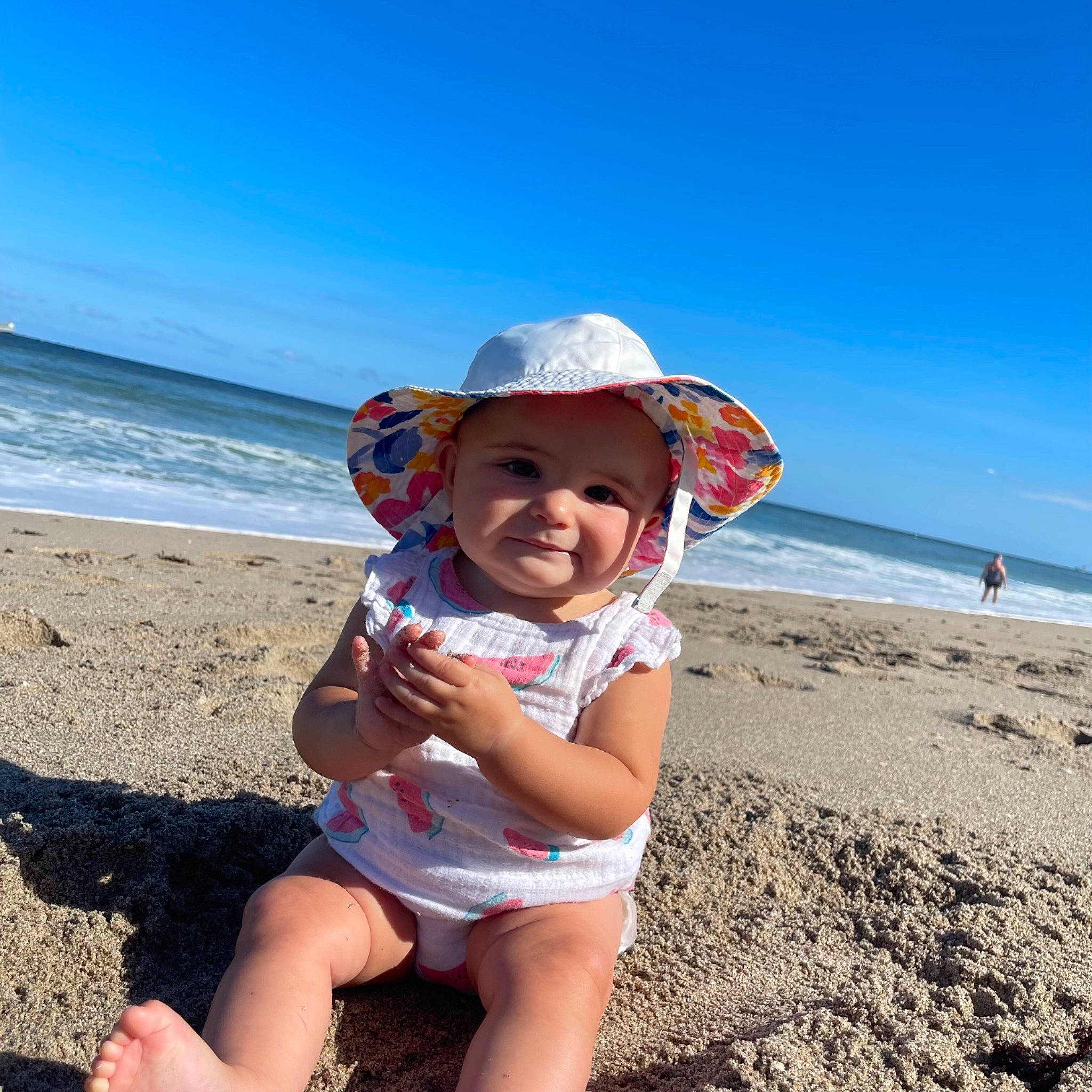 Paisley is registered to the contest to win money with this photo: baby_toddler_clothing, beach, beauty, fun, happy, hat, headwear, holiday, landscape, leisure, people_in_nature, people_on_beach, person, sand, sky, smile, sun_hat, thigh, toddler, travel