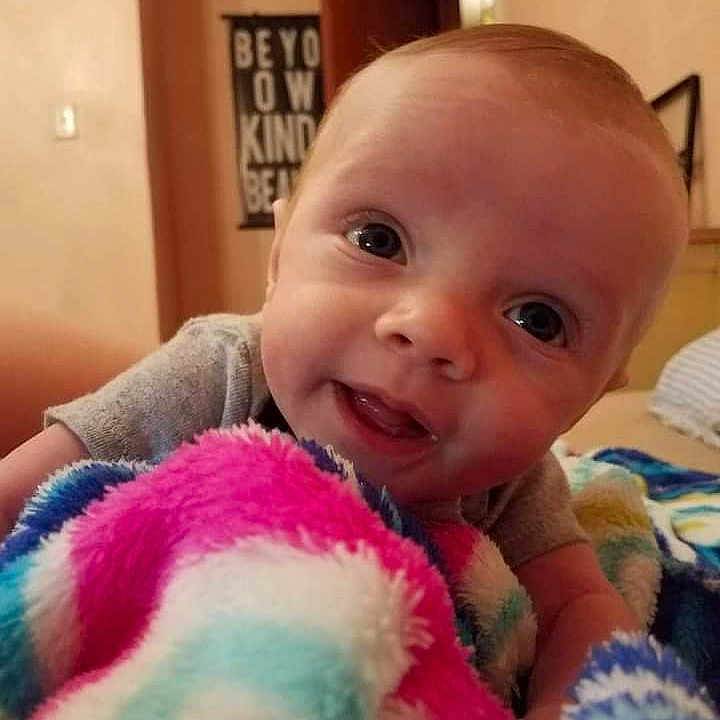 Oliver is registered to the contest to win money with this photo: baby, babylaughing, blanket, face, happy, head, laughing, newborn, person, photoframe, photography, portrait, quilt, smile, towel