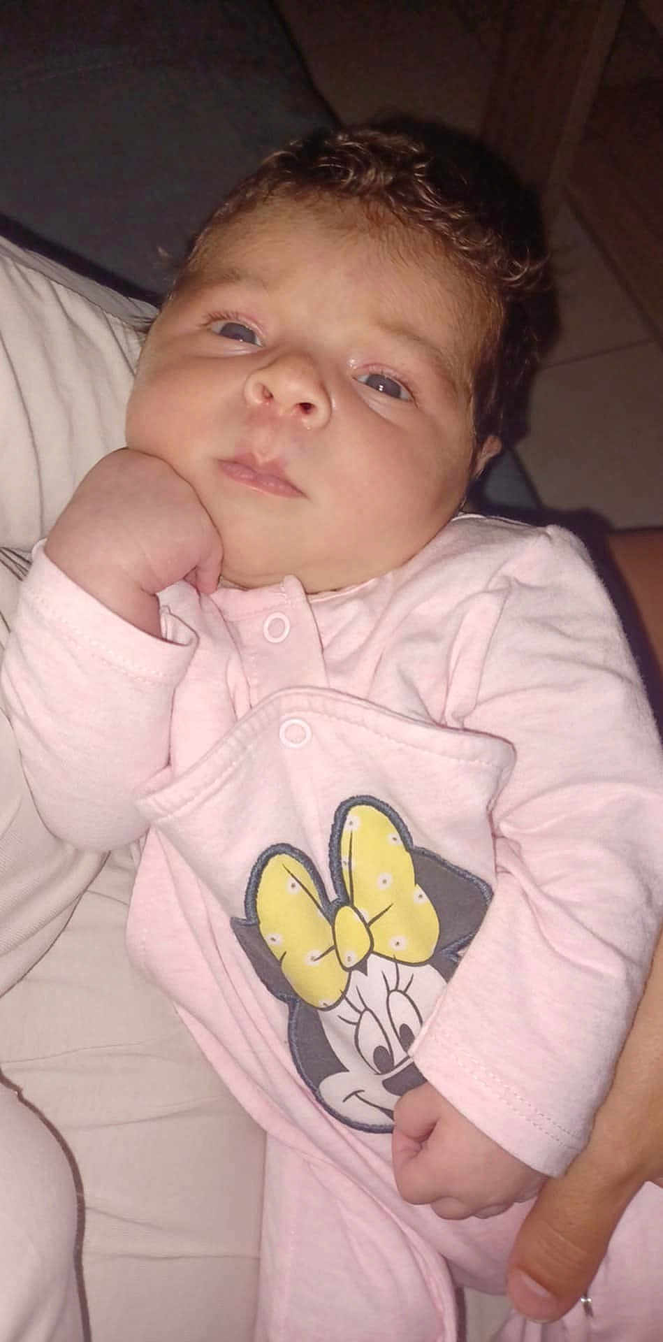 Elyça a rejoint le concours — aidez-le/la à gagner de superbes lots ! baby, infant, pink_clothing, minnie_mouse, hand, face, curly_hair, person, cute, child, resting, expression, holding, indoor, portrait, closeup, soft_lighting, casual, human, toddler