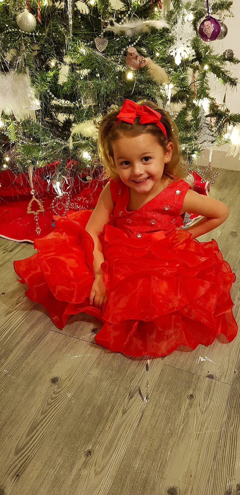 D'Joulya participe au concours pour gagner de l'argent avec cette photo : child, child_model, clothing, costume, dress, flower_girl, hair_accessory, joy, person, red, smile, toddler