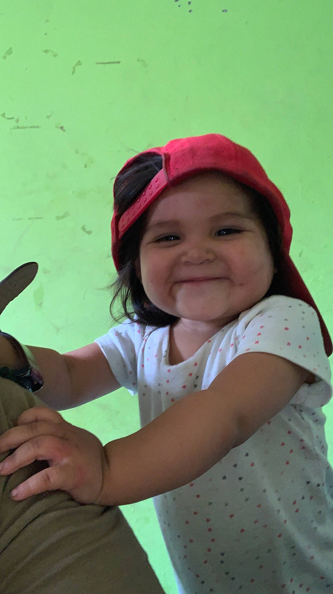 Juana is registered to the contest to win money with this photo: arm, baby_toddler_clothing, baseball_cap, cap, child, elbow, face, fun, grass, hand, happy, headwear, joy, leisure, magenta, person, recreation, sitting, skin, sleeve