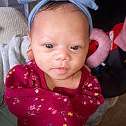 Mi'Amor is registered to the contest to win money with this photo: baby, blue, bow, child, clothing, cute, expression, eyes, face, floral_pattern, headband, indoor, infant, looking, person, portrait, red, skin, soft_light, young_child