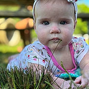 Stella joined the competition — help win amazing prizes! baby, child, closeup, colorful_clothing, curious, drool, expression, face, grass, greenery, headband, infant, laying, nature, outdoor, portrait, skin, summer, sunlight, toddler