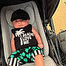 baby, infant, stroller, cap, black_clothing, tropical_print, palm_tree, shorts, sleeveless_shirt, cute, child, outdoor, sunny, seat, fabric, person, legs, expression, casual, summer