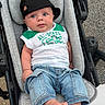 Maximus joined the competition — help win amazing prizes! baby, infant, child, stroller, cap, hat, jeans, clothing, casual, cute, face, blue_eyes, sleeveless_shirt, green, white, foot, outdoor, pavement, portrait, person