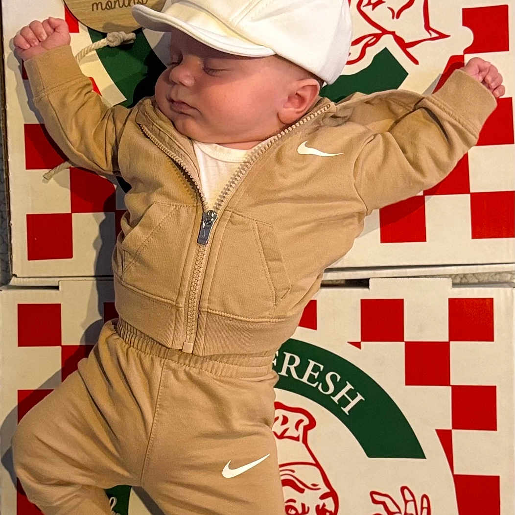 Maximus joined the competition — help win amazing prizes! baby, sleeping, tracksuit, beige_clothing, white_cap, white_shoes, pizza_boxes, red_and_white, checkered_pattern, logo, brand, food_packaging, child, infant, casual_wear, resting, cute, indoor, person, apparel