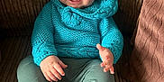 Elliott is registered to the contest to win money with this photo: baby, smiling, blue_hat, knitted_sweater, sitting, couch, white_shoes, happy, child, infant, cute, portrait, cozy, indoor, clothing, hands, feet, face, young_child, nike