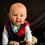 Elliott is registered to the contest to win money with this photo: baby, child, infant, portrait, sitting, smiling, clothing, sweater_vest, long_sleeve, cute, face, blue_eyes, skin, hands, indoor, candid, young, person, head, expression