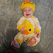 Daniel is registered to the contest to win money with this photo: baby, infant, smiling, yellow_hat, duck_outfit, cute, happy, lying_down, blanket, soft_texture, feet, child, one_person, indoors, playful, adorable, clothing, headwear, expression, portrait