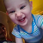 Giovanni is registered to the contest to win money with this photo: baby, bedroom, blue_clothing, casual_photo, child, close_up, eyes, face, family, green_clothing, happy, indoor, leaning, portrait, second_person, sitting, smiling, striped_shirt, teeth, warm_lighting