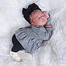 Brielle is registered to the contest to win money with this photo: baby, sleeping, infant, black_bow, grey_clothing, white_fluffy_background, soft_texture, peaceful, cute, newborn, headband, lying_down, child, cozy, indoors, portrait, small_hands, black_pants, footwear, resting