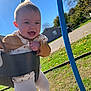 Maisie is registered to the contest to win money with this photo: baby, child, swing, playground, outdoor, grass, blue_sky, sunlight, happy, smiling, clothing, tights, flower_pattern, fall, tree, park, person, play, fun, seat