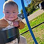 baby, child, swing, outdoor, playground, smile, happy, grass, blue_sky, park, clothing, tights, seat, sunlight, daylight, person, tree, vehicle, road, hand