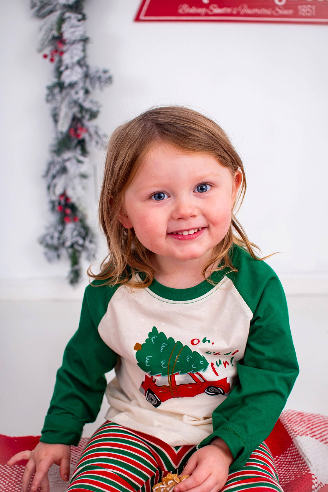 Baylee is registered to the contest to win money with this photo: baby_toddler_clothing, child, christmas, christmas_decoration, christmas_ornament, event, eye, face, hair, happy, head, holiday, joy, pattern, person, red, skin, sleeve, smile, sock