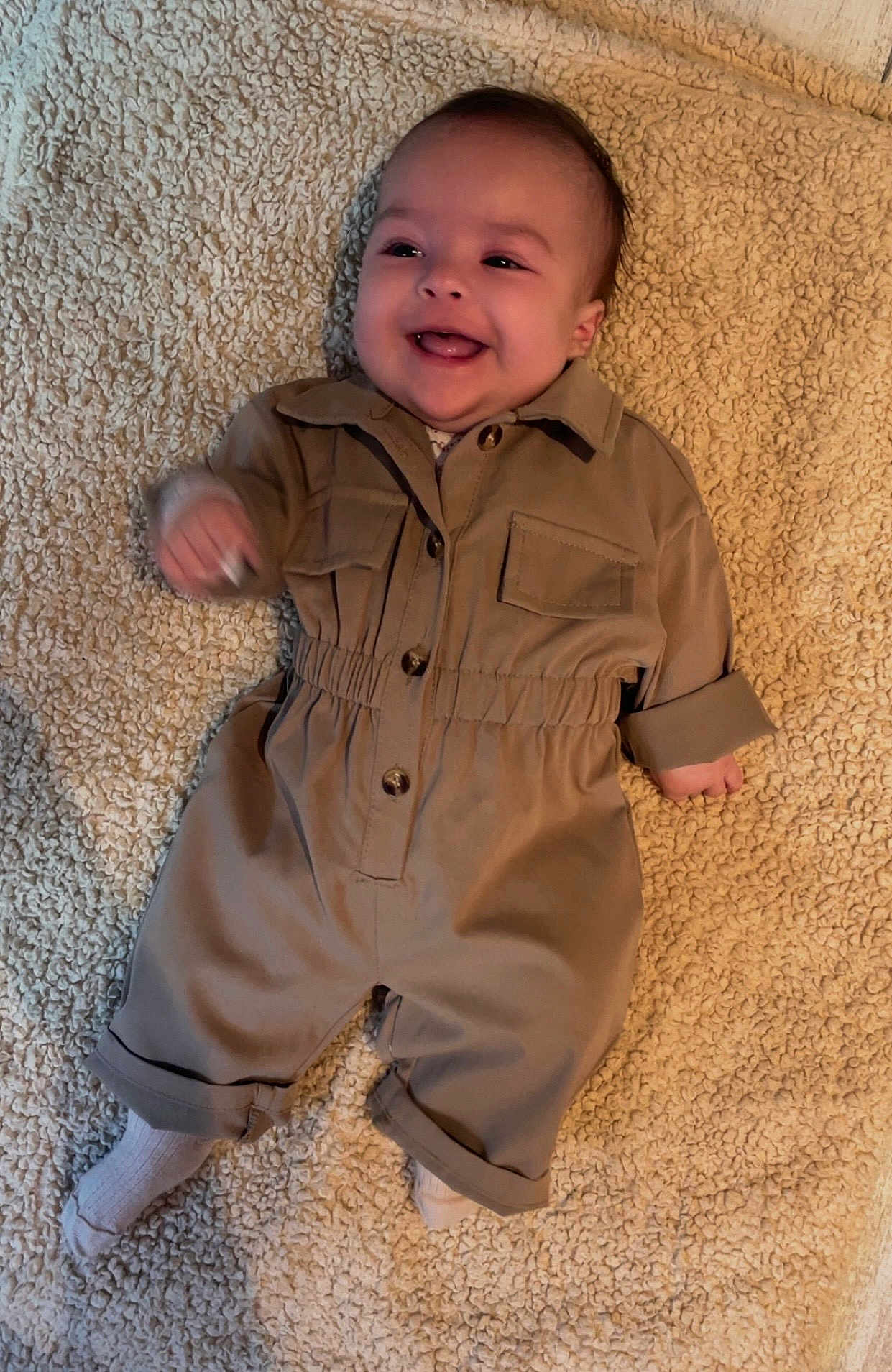 Loëlya a rejoint le concours — aidez-le/la à gagner de superbes lots ! baby, smiling, infant, jumpsuit, tan_clothing, blanket, white_socks, happy, lying_down, cute, child, cozy, portrait, indoor, soft_texture, small_hands, baby_face, comfortable, adorable, young_child