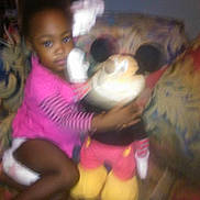 Mykala is registered to the contest to win money with this photo: blurry, casual, child, couch, cute, furniture, home, hugging, indoor, living_room, mickey_mouse, patterned_couch, person, pink_clothing, plush_toy, seated, soft_focus, toddler, toy, young_child