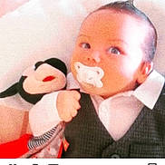 Pille James participe au concours pour gagner de l'argent avec cette photo : baby, baby_clothes, child, clothing, cute, expression, face, family_photo, hand, indoors, infant, lying_down, mickey_mouse, pacifier, plush_toy, portrait, shirt, soft_focus, toy, vest