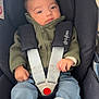baby, child, car_seat, seat_belt, jacket, green_jacket, socks, blue_jeans, infant, straps, sitting, indoor, cute, portrait, person, young_child, clothing, baby_clothes, safety, seat