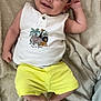 baby, child, smiling, face, yellow_shorts, white_shirt, animal_print, blanket, lying_down, cute, happy, infant, skin, head, arm, hand, foot, toe, indoors, cozy