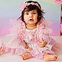baby, child, girl, pink_dress, headband, flower, sitting, cute, portrait, indoors, soft_lighting, tulle, sequins, happy, barefoot, infant, adorable, closeup, decor, pastel_background